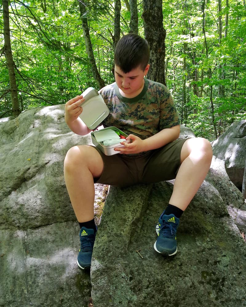 The boy taking a break from his hike to have a snack from his Trangia tin.