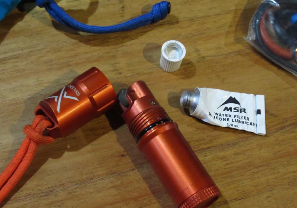 Exotac Titan Lighter on table with MSR water filter lubricant for maintenance