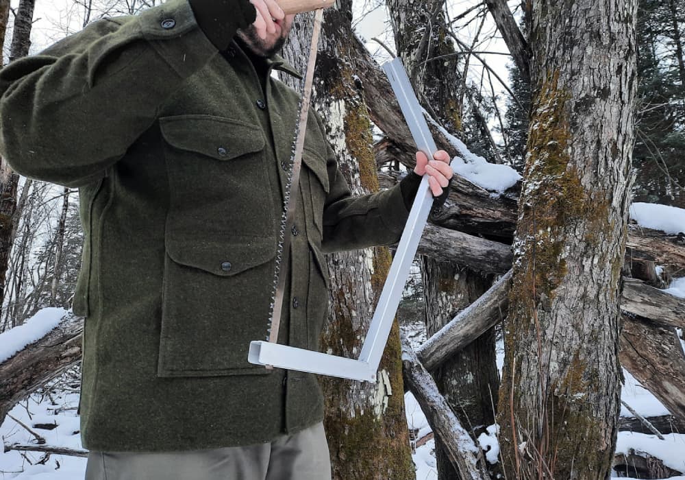 Green Filson Mackinaw Jacket worn while using a Folding Saw