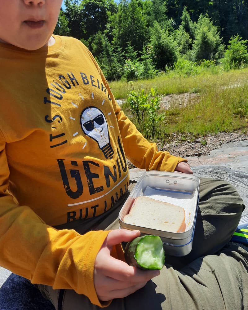 Alternate image of the boy enjoying his lunch outside using his Trangia tins.